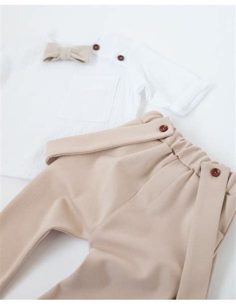 Berniukas vilkiąs smėlio spalvos lininį krikšto kostiumėlį