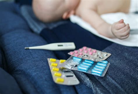 vaikas su termometru matuojasi temperatūrą