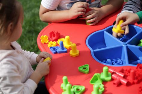 suaugęs stebi kūdikį žaidimų lovelėje