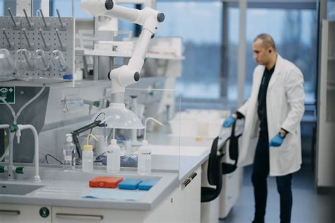 Laboratorijos darbuotojas, dirbantis su mikroskopu