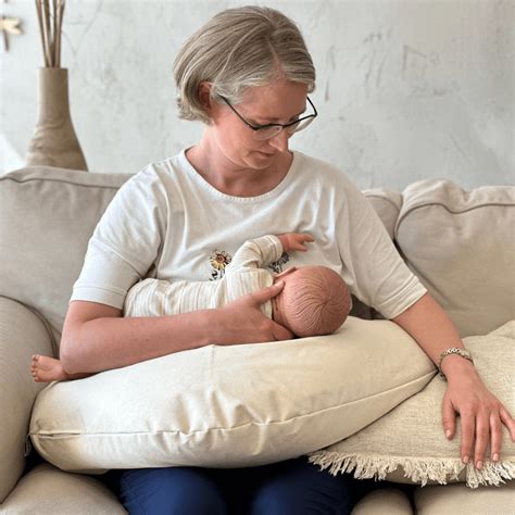 Moteris su kūdikiu, naudojanti maitinimo pagalvę