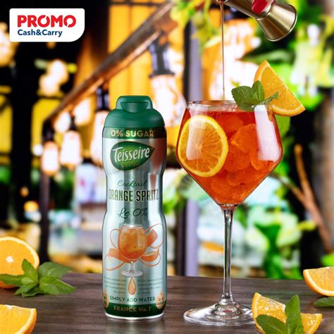 Nėščios moters ranka laiko stiklinę su vaisiniu nealkoholinio kokteilio