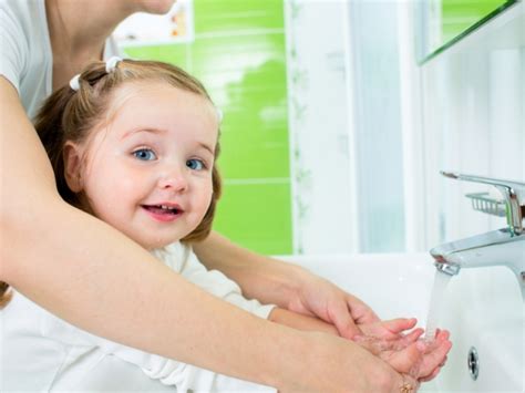 Vaikas plauna rankas su muilu