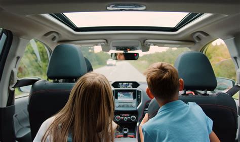 Šeima, keliaujanti automobilyje su vaikais ant galinės sėdynės