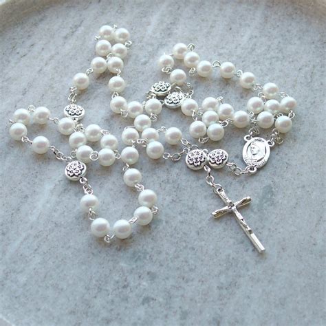 religiniai simboliai: kryželis, rožančius, medalikėlis