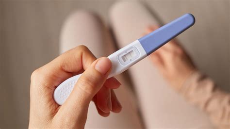 Moters ranka, laikanti nėštumo testą su neigiamu rezultatu