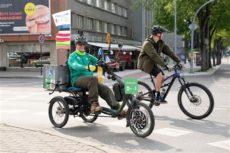 Žmogus su elektriniu triračiu vežimėliu parduotuvėje