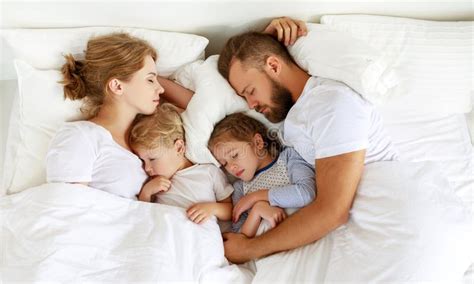 Family sleeping in one bed