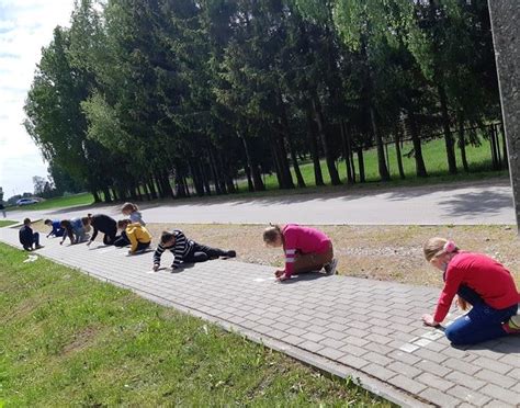 vaikai piešia ant popieriaus sėdėdami ant vaikiškų kėdučių