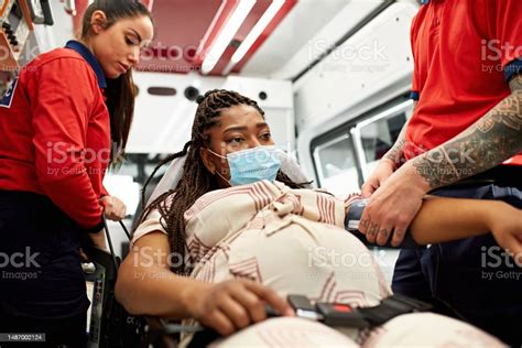 pregnant woman being helped by paramedics