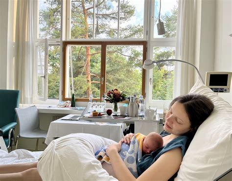 Akušerės dirbanti su naujagimiu