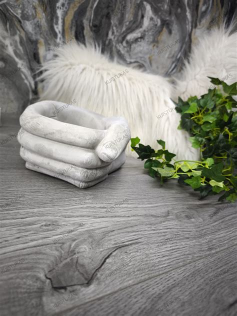 Simbolinis vaizdas - rankos, laikančios kūdikį