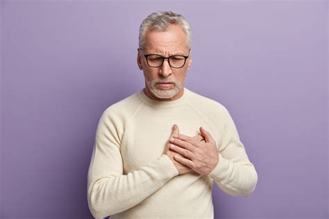 Žmogus, laikantis už krūtinės, su skausmo išraiška