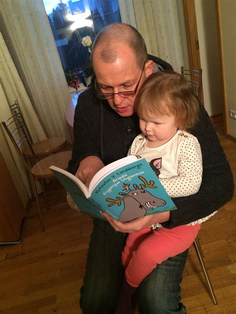 tėvas su vaiku skaito knygą