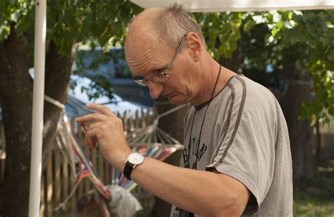 Vyras su rūpesčiu žiūri į mikroskopą