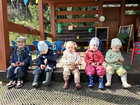 vaikų grupė su įvairiais kostiumais, įskaitant mėlynus kombinezonus
