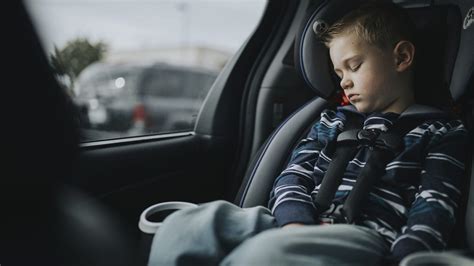 vaikas automobilinėje kėdutėje žiūri pro langą