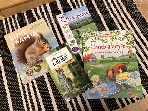 Vaizdas su vaikais skaitančiais knygą gamtoje