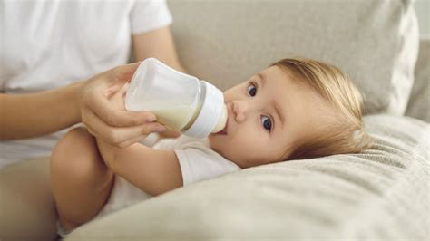 vaikas geria pieną iš buteliuko