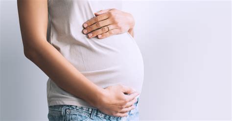 Nėščią moterį, laikančią rankose nėštumo vadovą