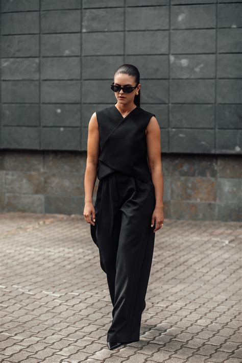 Juodo kombinezono detalių pavyzdys: asimetriška iškirptė