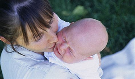 Moteris su kūdikiu patogiai įsitaisiusi žindyti