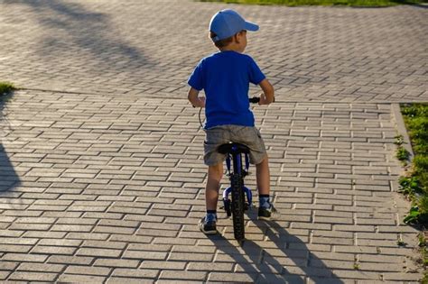 vaikas su Žmogaus-Voro šalmu važiuoja dviračiu